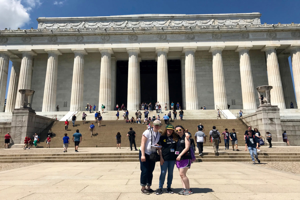 Three high school students standing in front of a Capitol building.