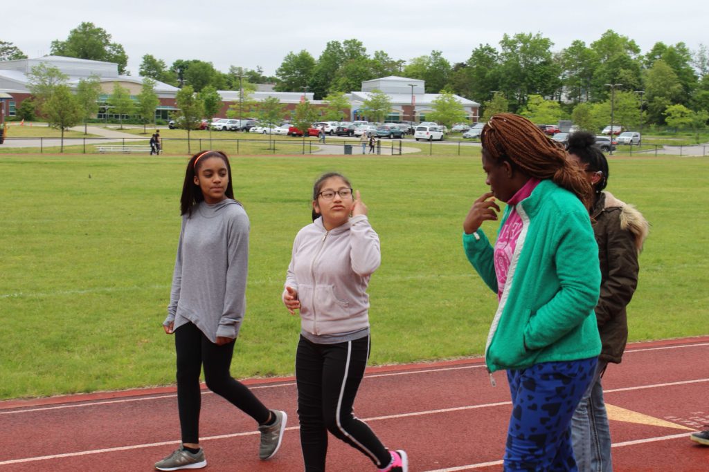 Four high school girls walking on a running track.