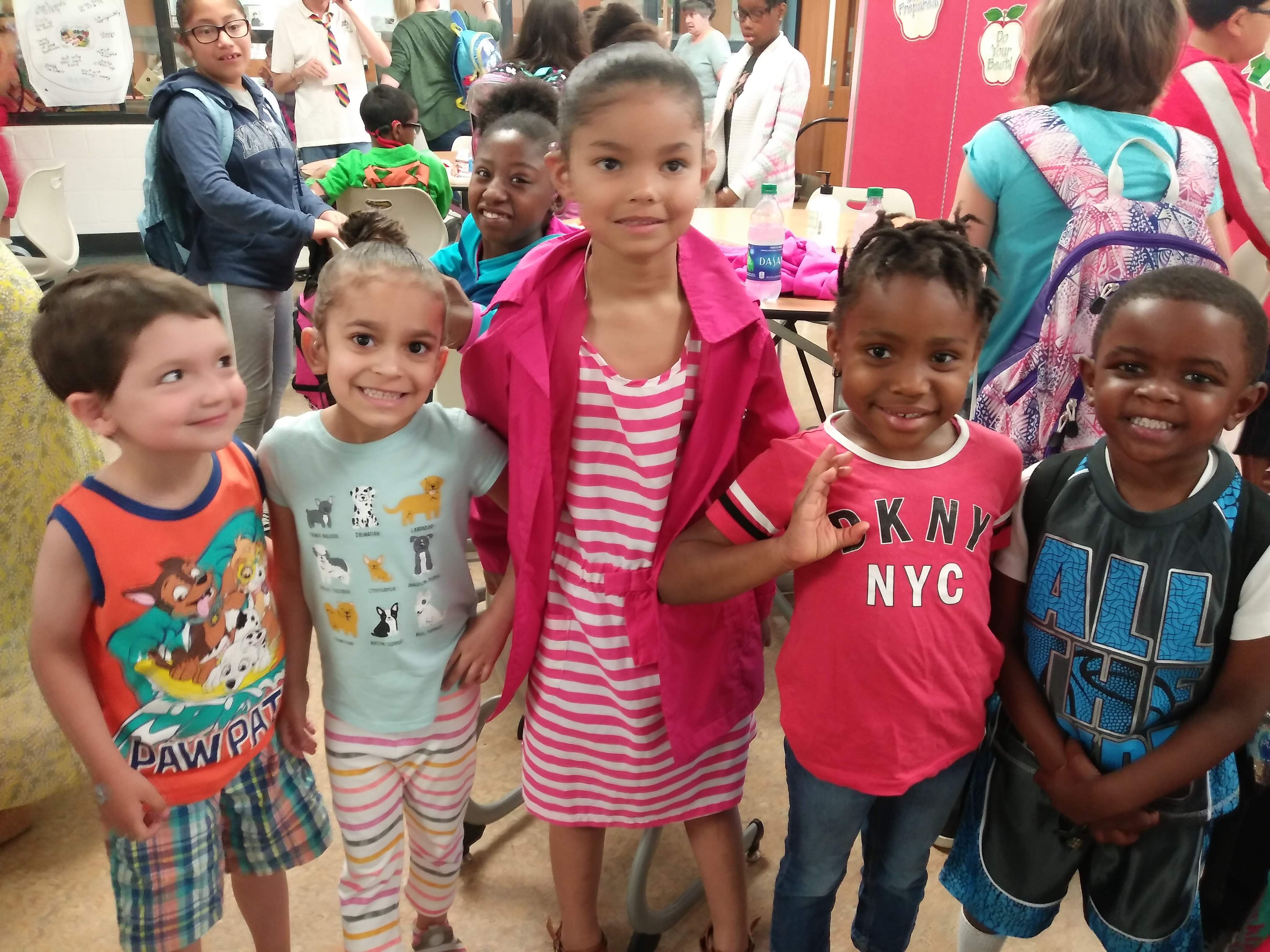 Five preschoolers standing together.