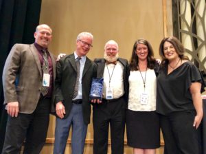 Group of five four adults standing with an award winner.