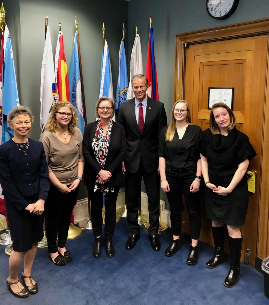 Five advocates with Senator in his office.