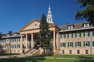 Large two story brick building with portico and cupola.